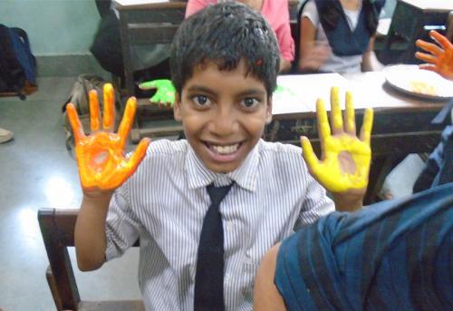 mentee-excitedly-holds-up-his-coloured-hands-main